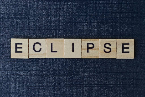 texto em eclipse palavra de letras de madeira cinza em um fundo preto
 - Foto, Imagem