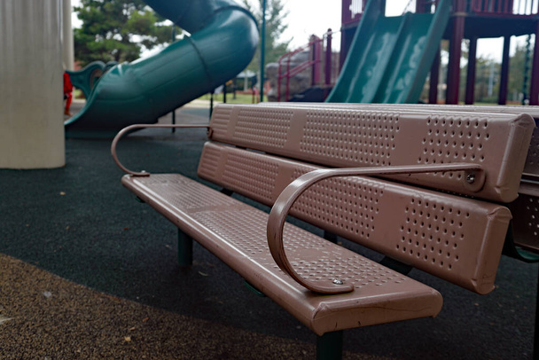 Assento de banco vazio no parque infantil com equipamento no dia ensolarado
 - Foto, Imagem