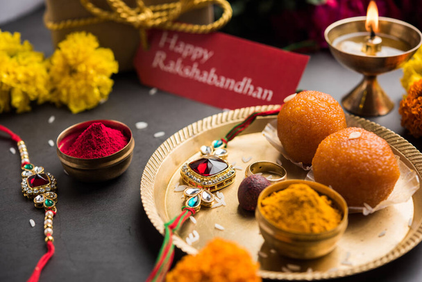 Raksha Bandhan / Rakshabandhan Rakhi met Haldi Kumkum rijst, zoete Mithai, Geschenkdoos, selectieve focus - Foto, afbeelding