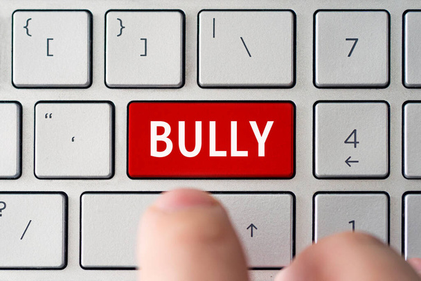 La palabra bullying en el teclado gris de la computadora. El concepto de intimidación y humillación por acoso en la red. - Foto, imagen