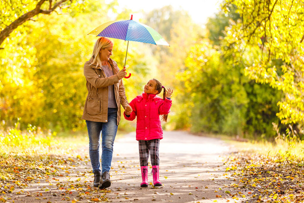 Young mother and her little daughter outdoors in colorful raincoats - Photo, Image