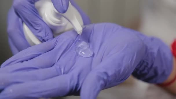 Professional beautician puts gel on gloves and rubs it. - Video, Çekim