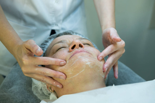 Egy látogatás egy kozmetikusnál. Orvos kozmetikus készíti fel a beteg arcát az eljárásra - karboxterápia. Az előkészítő szakasz mosás. - Fotó, kép