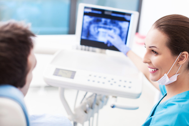 Dentista che mostra la radiografia dei denti al paziente
 - Foto, immagini