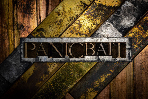 Panicbait tekst gevormd met echte authentieke lettertype letters op vintage getextureerd zilver grunge koper en goud achtergrond - Foto, afbeelding