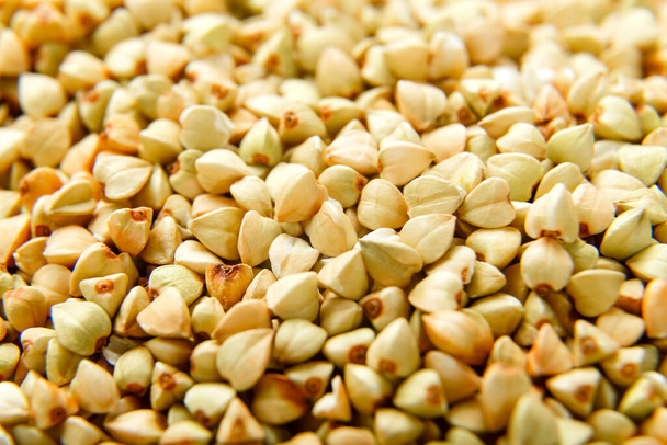 Green buckwheat scattered on the surface macro shot. - Foto, Imagen