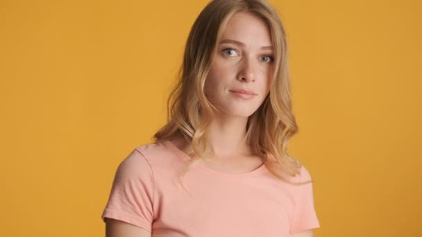 Attractive blond girl intently looking in camera over colorful background. Face expression - Footage, Video