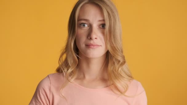 Beautiful smiling blond girl confidently looking in camera over colorful background. Face expression - Footage, Video