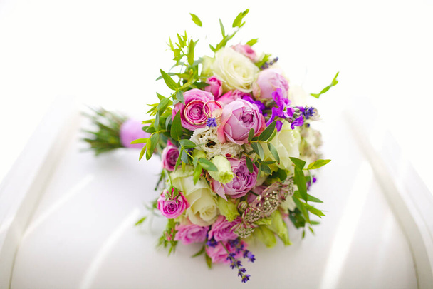 Primer plano de anillos de boda de oro de ramo de flores jóvenes y frescas de rosas y otras flores hermosas florecientes
 - Foto, imagen