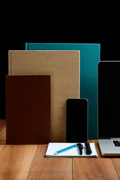 Electronic gadgets, books and stationery on wooden table - Foto, afbeelding