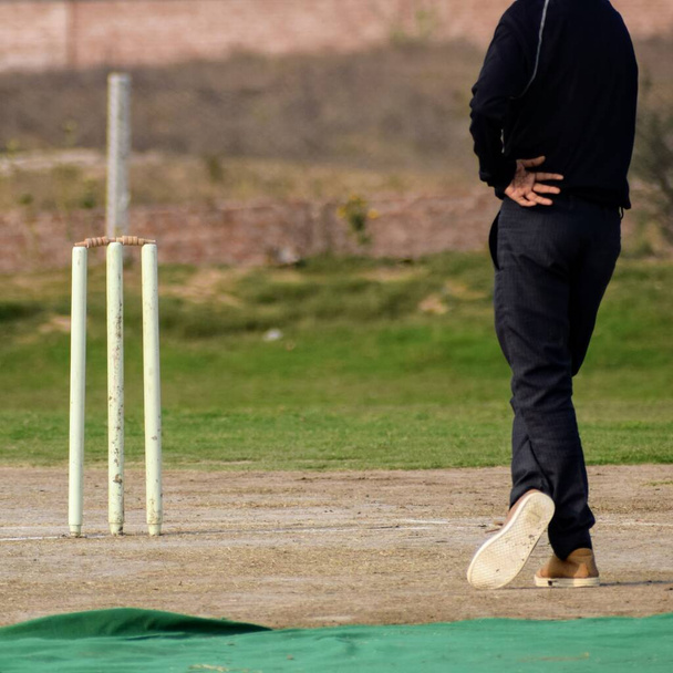 Полная продолжительность игры в крикет на поле в солнечный день, крикет на поле в действии, игроки играют в крикет на поле в течение дня - Фото, изображение