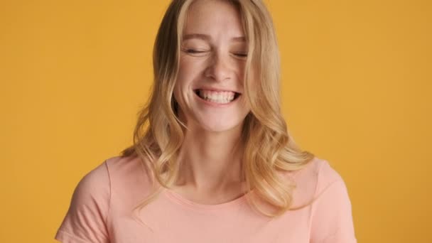 Attractive smiling girl happily looking in camera over colorful background. Cheerful expression - Záběry, video