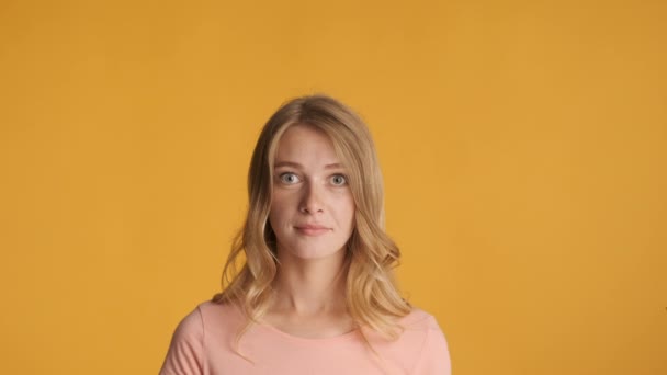 Pretty cheerful blond girl surprisingly looking in camera over colorful background. New idea expression - Footage, Video