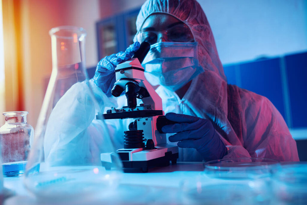 Doctor in the laboratory analyzes samples under a microscope. Pharmaceutical treatment concept. - Photo, image