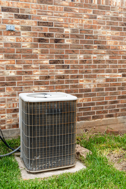 Older HVAC air conditioner system next to brick home with copy space - Photo, Image