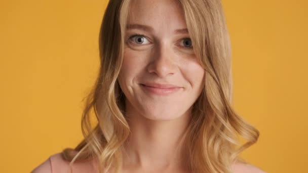 Portrait of pretty blond girl happily raising eyebrow on camera over colorful background. Fooling around expression - Footage, Video
