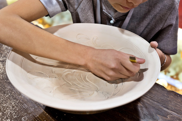 handicraftsman engrave a white dish - Photo, Image