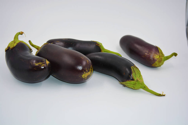 Fresh blue, purple eggplants recently picked and arranged on a matte white background. Delicious vegetables that grow in Ukraine, healthy and wholesome food for every day. - Photo, Image