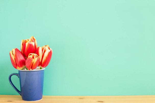 Czerwony tulipan kwiaty na drewnianym stole z miętowym zielonym tle. kompozycja kwiatowa, przestrzeń do kopiowania - Zdjęcie, obraz