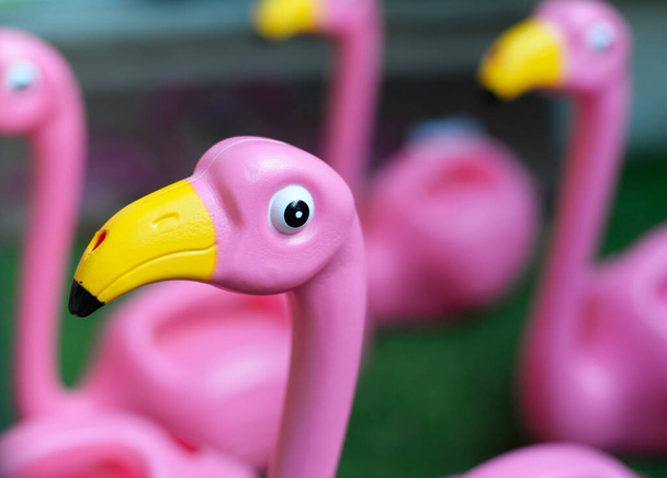 plastic bright pink flamingo's with yellow beak, selective focus - Fotografie, Obrázek