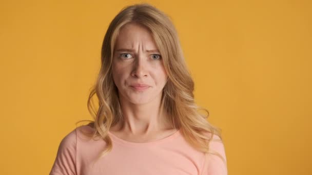 Young displeased blond woman angrily breathing on camera over colorful background. Irritated expression - Footage, Video