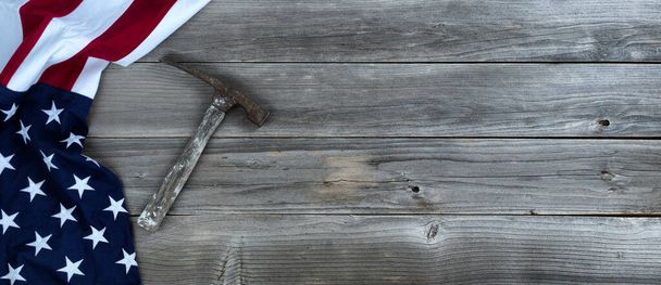 Vintage construction hammer with waving US Flag on rustic wooden background with copy space - Foto, Bild