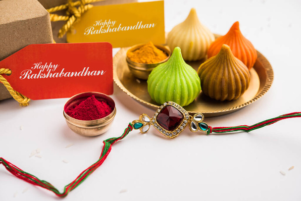Raksha Bandhan / Rakshabandhan Rakhi με ρύζι Haldi Kumkum, γλυκό Mithai, κουτί δώρου, επιλεκτική εστίαση - Φωτογραφία, εικόνα