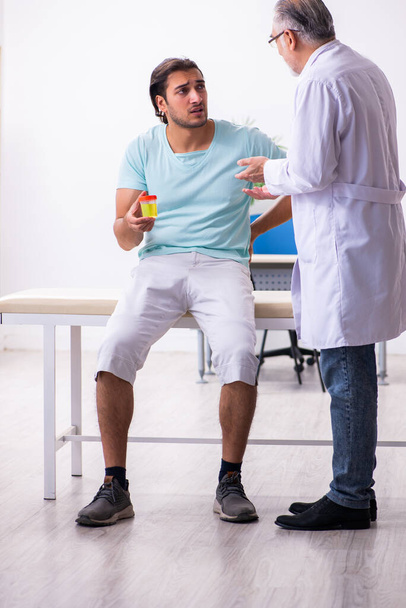 Genç erkek hasta, deneyimli doktoru ziyaret ediyor. - Fotoğraf, Görsel