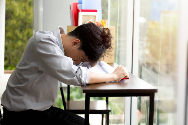 Aziatische man is gestrest omdat hij ontslagen is van zijn werk. Medewerkers ontslagen wegens economische neergang en epidemie COVID-19. - Foto, afbeelding