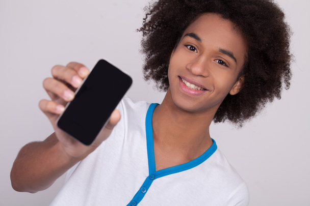 African teenager showing his mobile phone - Foto, Imagen