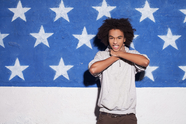 Young and carefree. Young African man posing against American flag - Фото, зображення
