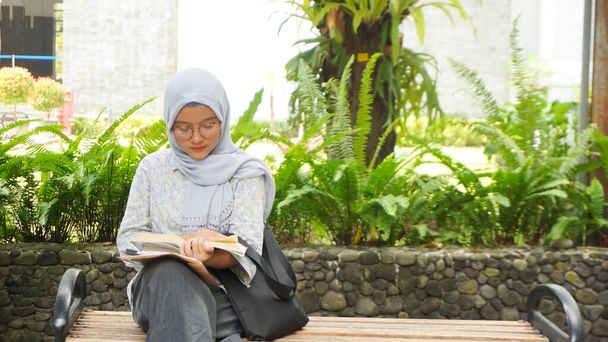 Azji hidżab dziewczyna czytanie w kampusie ogród - Zdjęcie, obraz