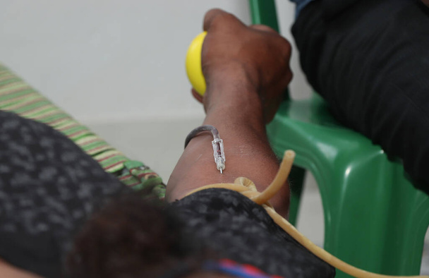 Donneur de sang lors d'un don avec une boule gonflable tenant en main. image originale pour Journée mondiale des donneurs de sang-14 juin. - Photo, image