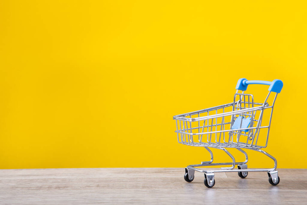 close-up of shopping trolley on yellow background with some copy space - Photo, Image