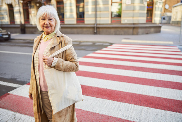 Outdoor portrait of senior female on the pedestrian crossing - Zdjęcie, obraz