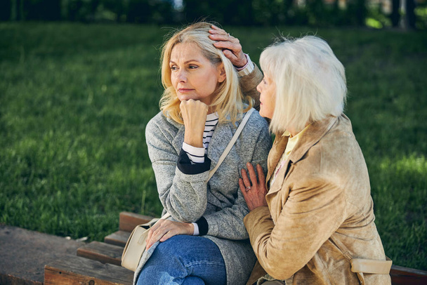 Two Caucasian women thinking about something in the part - Foto, Bild