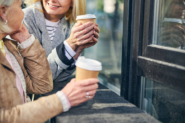 Two smiling women is enjoying coffee outdoors - Foto, afbeelding