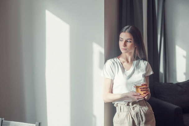 Beautiful woman drinking morning tea behind window. Challenge of a new day. Copy space - Фото, зображення