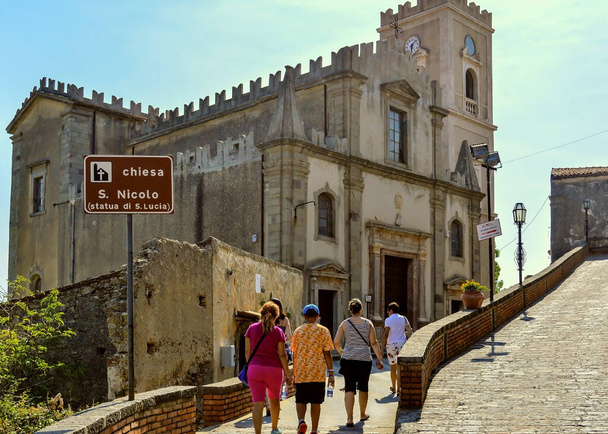 SAVOCA, SICILY, ITALY, August 15 2015: A group of tourist with guide going toward church of Saint Nicolo in Savoca, Italy. - Foto, immagini
