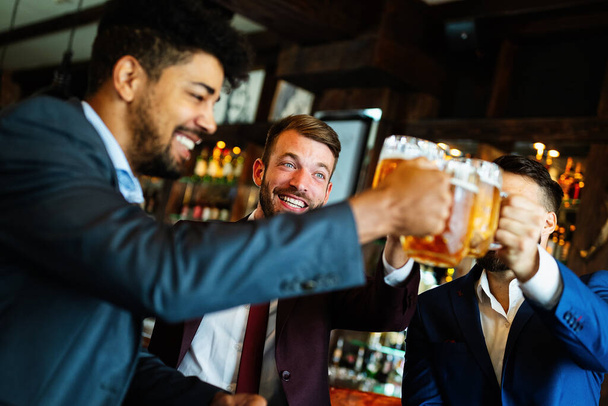 Amusant vieux amis, homme d'affaires s'amuser et boire de la bière au comptoir du bar dans le pub. - Photo, image