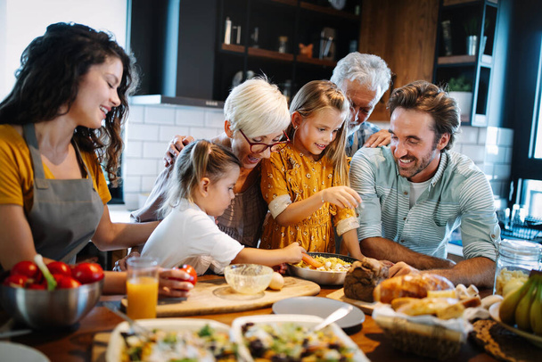 Grandparents, parents and children spending happy time in the kitchen. Family cooking concept - Foto, afbeelding