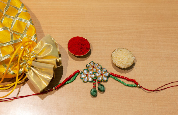 Индийский фестиваль, Ракша Бандхан фон с элегантным красочным Rakhi, подарок, рис зерна и Кумкум. Традиционная индийская браслет запястья, который является символом любви между братьями и сестрами. - Фото, изображение