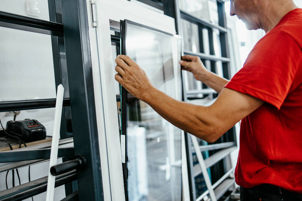 Manual worker assembling PVC doors and windows. Manufacturing jobs. Selective focus. Factory for aluminum and PVC windows and doors production. - Fotó, kép