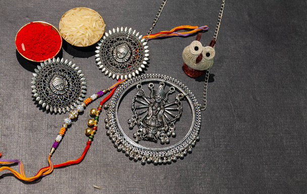 Festa indiana, sfondo Raksha Bandhan con un elegante Rakhi colorato, regalo, cereali di riso e Kumkum. Un braccialetto tradizionale indiano che è un simbolo di amore tra fratelli e sorelle. - Foto, immagini