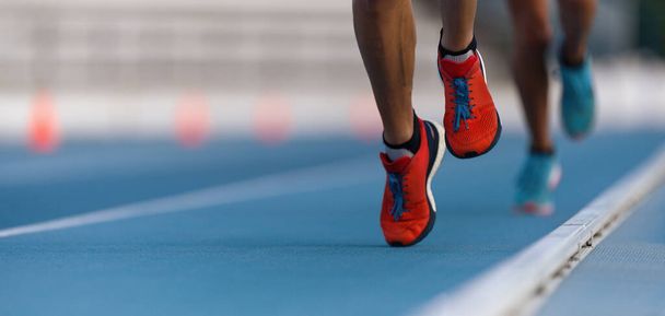 Los atletas velocistas corren velocidad en pista de estadio
 - Foto, Imagen