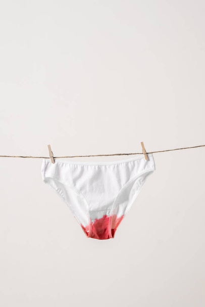 Womens underwear in menstrual fluid on clothesline. Concept photography for feminist blog. Poster about womens health - Foto, Imagem