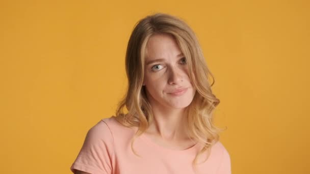 Beautiful annoyed blond girl rolling eyes boringly looking in camera over colorful background. Tired off expression - Footage, Video