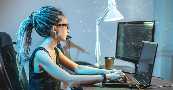 Moderne jonge vrouwelijke programmeur schrijft programmacode op een laptop thuis. Werk op afstand in de IT-sector. Het concept van softwareontwikkeling. - Foto, afbeelding