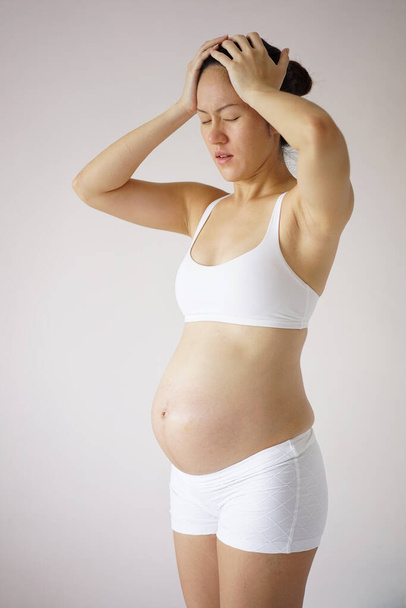 Азиатская китайская беременная женщина чувствует дискомфорт, вызванный беременностью - Фото, изображение