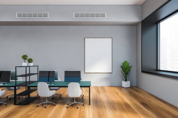 Interior of modern open space office with gray walls, wooden floor, blue computer tables with white chairs and windows with blurry cityscape. Vertical mock up poster. 3d rendering - Foto, afbeelding